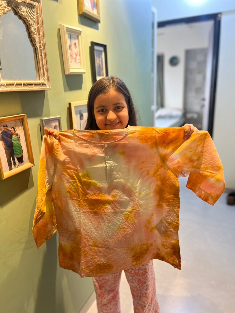 A child with a naturally dyed kurta that was rescued to give it a new life.