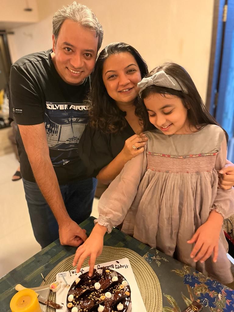 A family picture on a daughter's birthday. The daughter is wearing a hand-me-down dress.