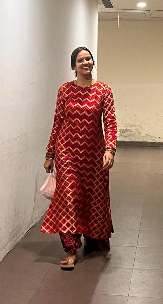 A woman in a red kurta and sharara.