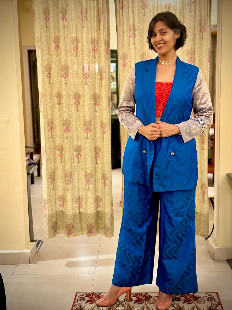 A woman wearing an upcycled blue pant suit.