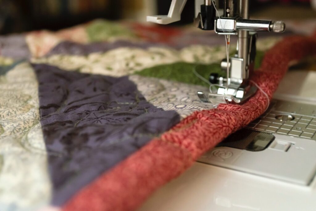 An image of a patchwork quilt being stitched 